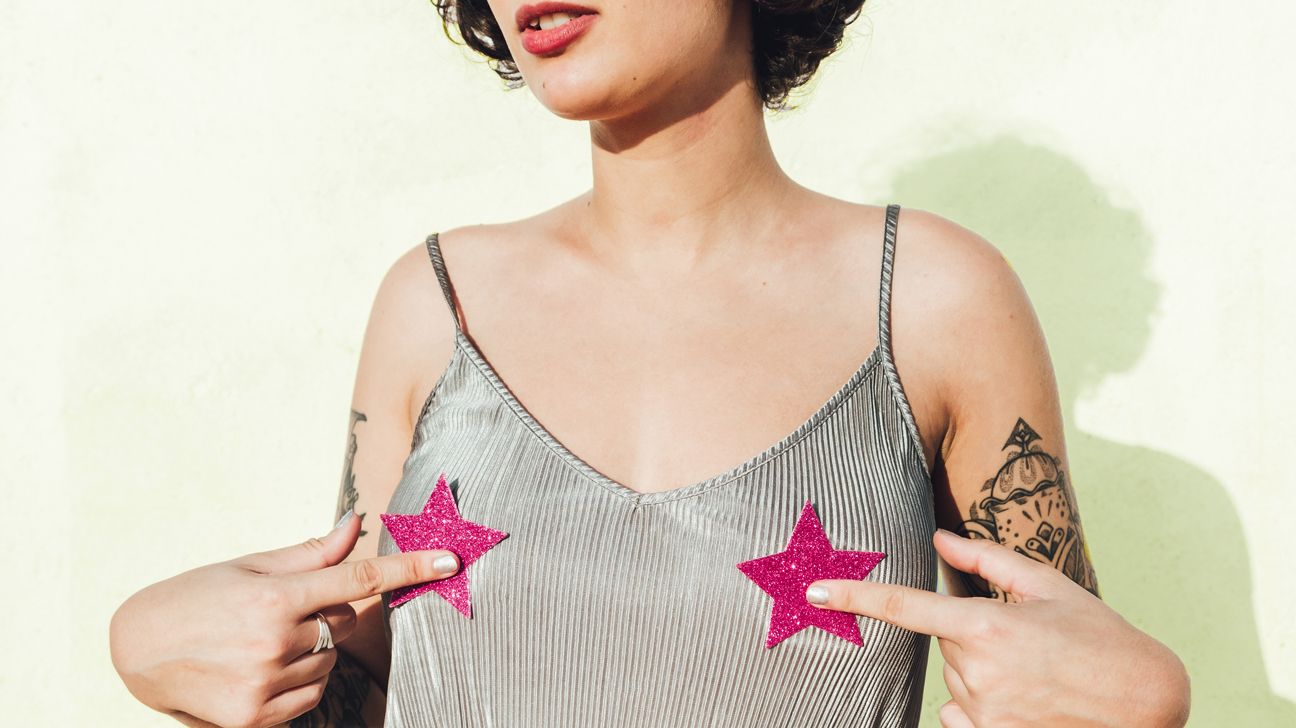 Young woman with star stickers on her breasts over a tank top