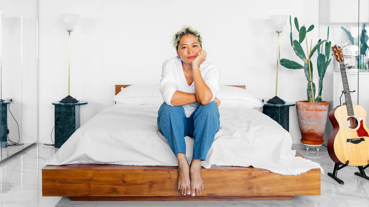 woman sitting on a bed looking concerned